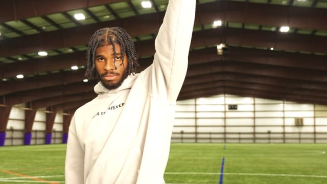 Shedeur Sanders holds a football in a photo shoot.